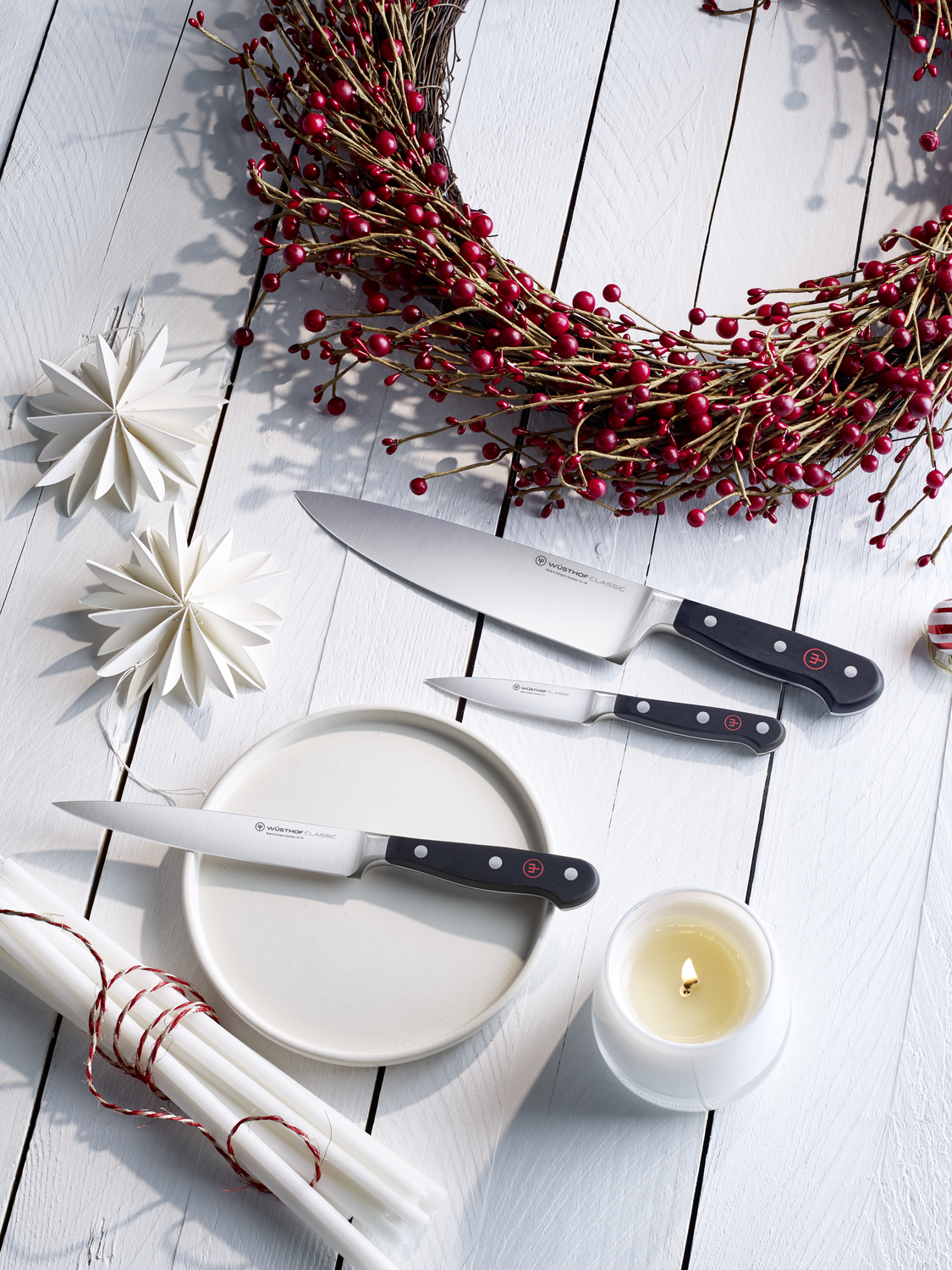 WÜSTHOF Classic Knives surrounded by a red wreath and a white candle