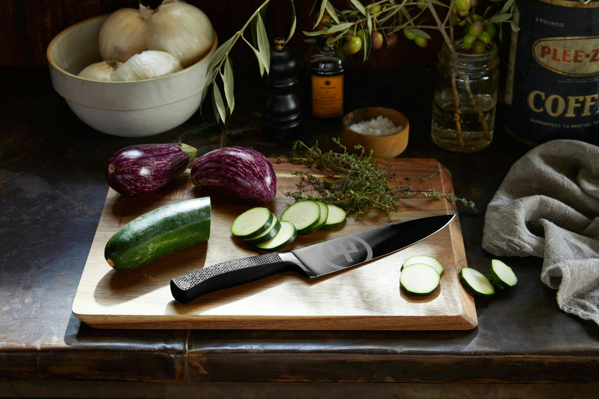 Wusthof Performance Series knife on a cutting board with freshly-sliced cucumber and eggplant