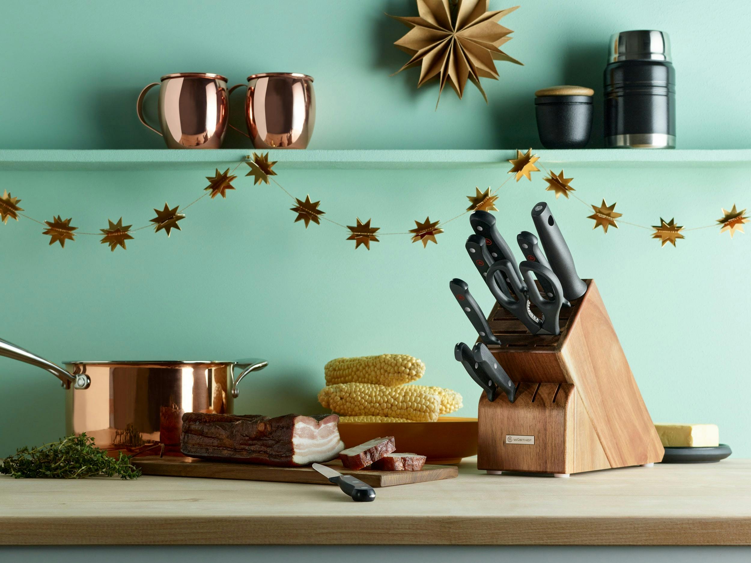Knife block next to holiday star garland on kitchen counter