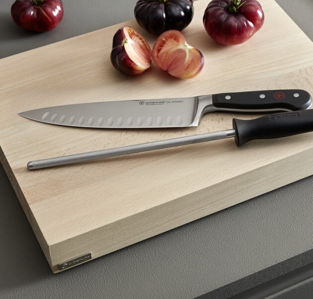 a wusthof knife and honing steel on a cutting board